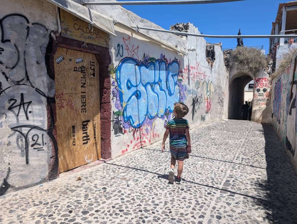Intentionally wandering with my son, who was unbothered by all of the graffiti on the streets of Santorini