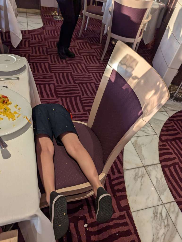 The realities of traveling with our kid: how he sits at dinner