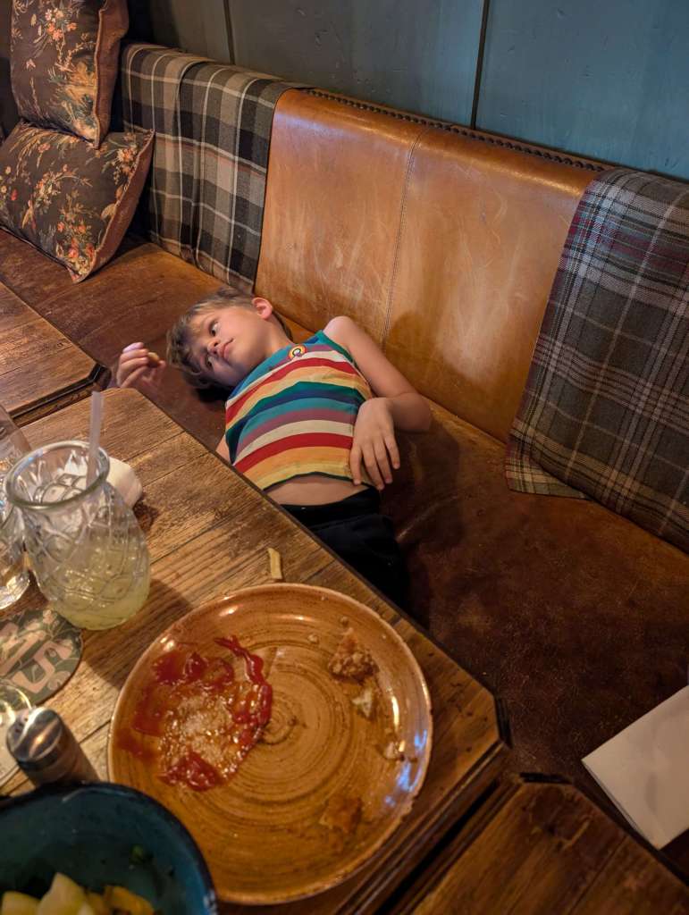 The realities of traveling with our kid: how he sits at dinner